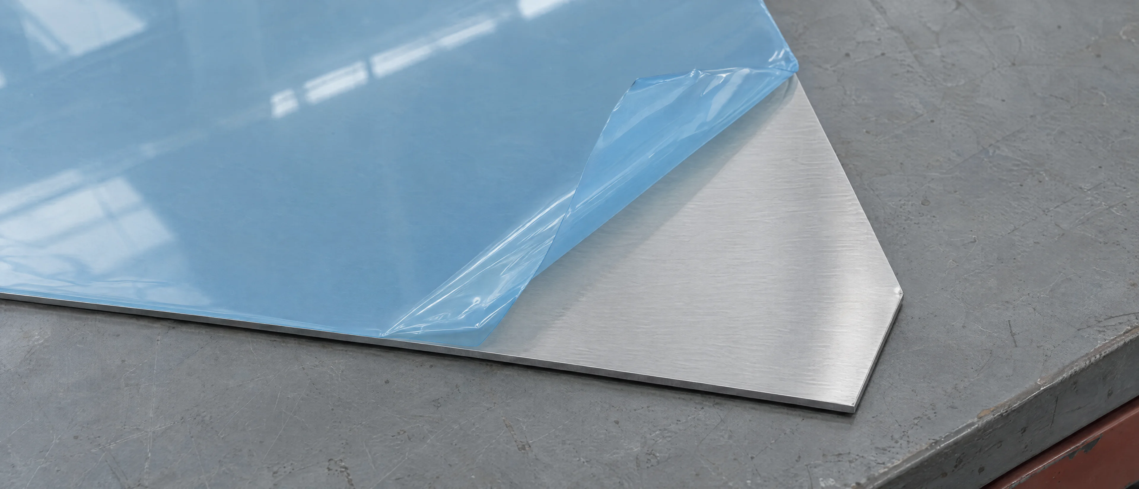 Aluminiumblech mit hellblauer Schutzfolie, eine Ecke ist abgezogen
