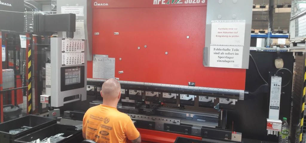 Mitarbeiter an einer Abkantpresse in der Fertigungshalle der STATEC