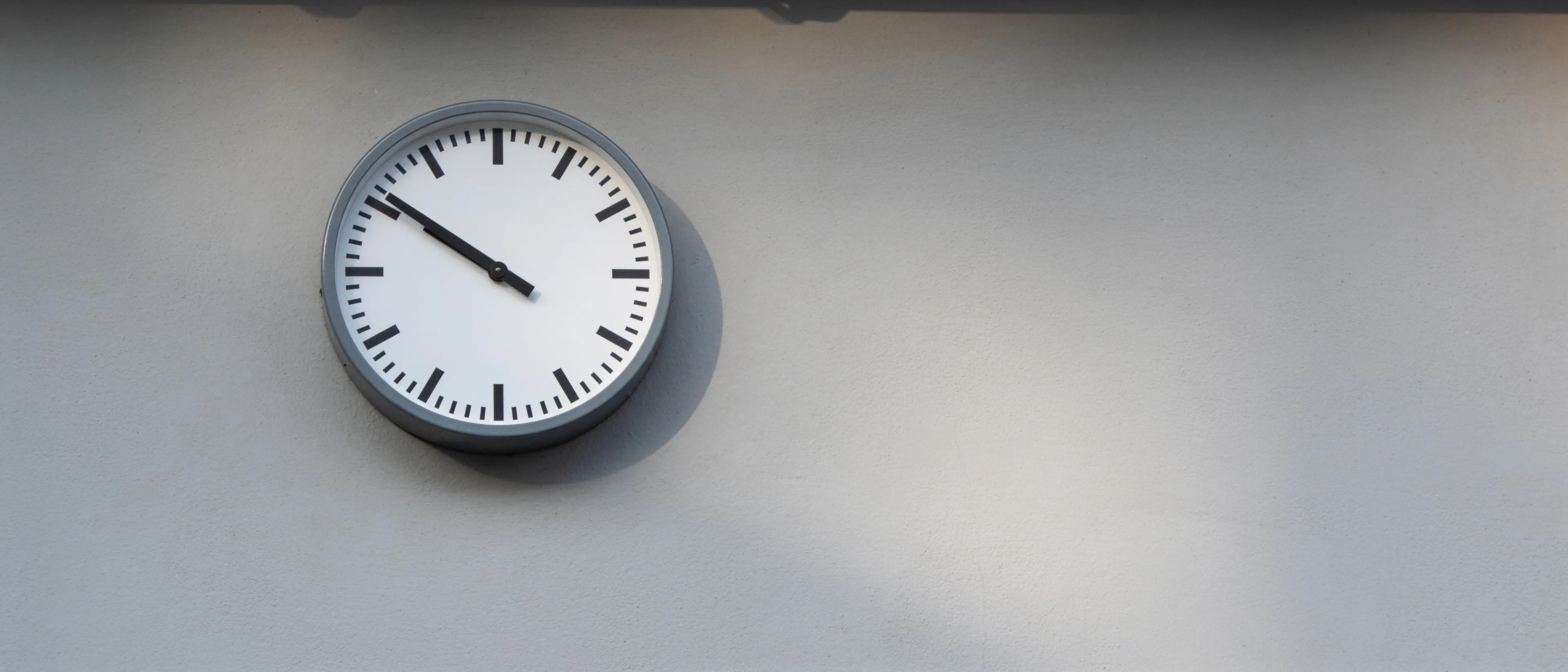 Schlichte Wanduhr an einer grauen Wand